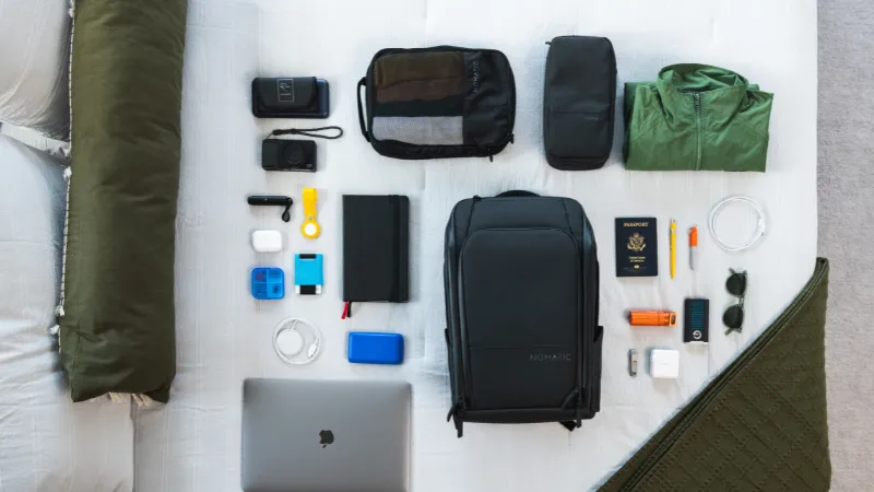 Laptop, mochila Nomatic y accesorios de trabajo y viaje
