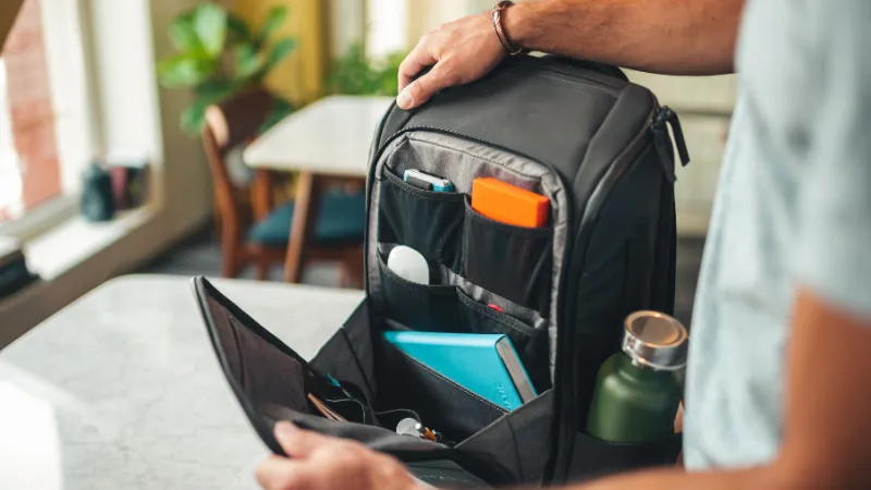 Mochila Nomatic abierta con dispositivos y accesorios organizados